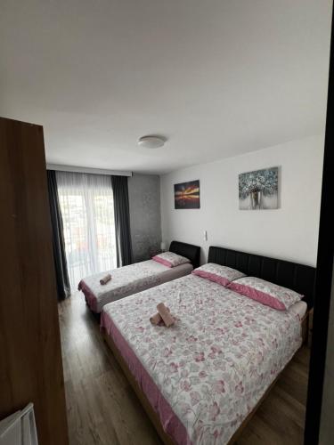 two beds in a bedroom with a cross on top of them at Apartmani Nika in Neum