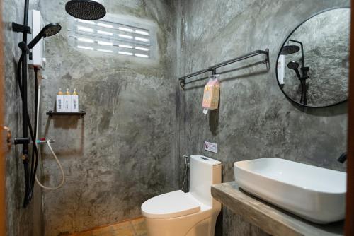 a bathroom with a sink and a toilet and a mirror at Fix25House Koh Kood in Ban Khlong Mat