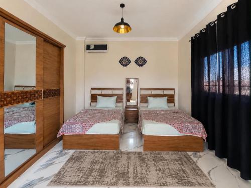 a bedroom with two beds and a window at Nubian Villa with Private Pool in Naj‘ al Aḩwāl
