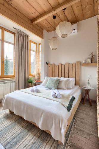 a bedroom with a large bed with two towels on it at Niedźwiedzia Residence Garden & Sauna in Poronin