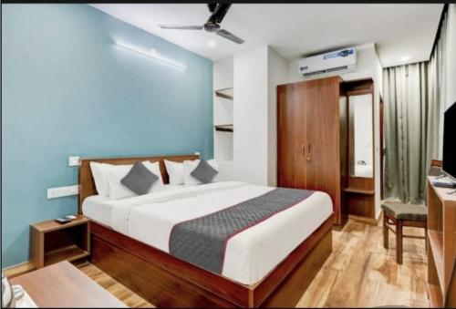a bedroom with a bed and a desk and a television at RLV green palace in Bangalore