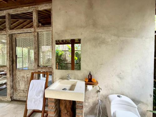 a bathroom with a sink and a bath tub at Sarini Joglo Villa by Manara in Blahbatu