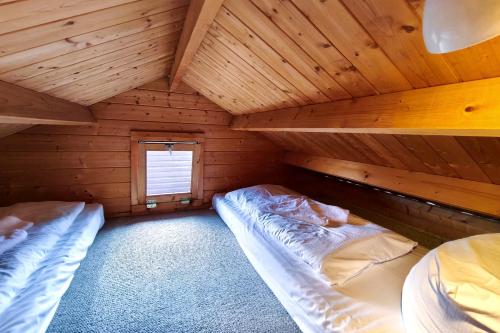 a bedroom with two beds in a wooden cabin at Ferienwohnung Reimann in Loddin