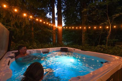 a man in a jacuzzi in a backyard at night at Yverin Muse Cabin in Glacier