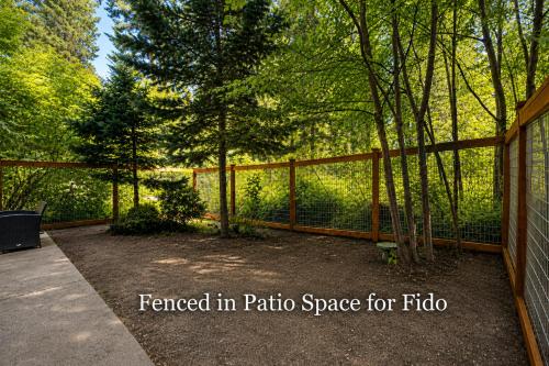 a fence in a yard with trees in the background at Pine River Retreat in Leavenworth