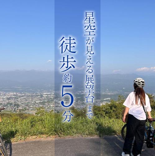 a woman standing next to a sign with chinese writing at PEDAL TERRACE in Iida
