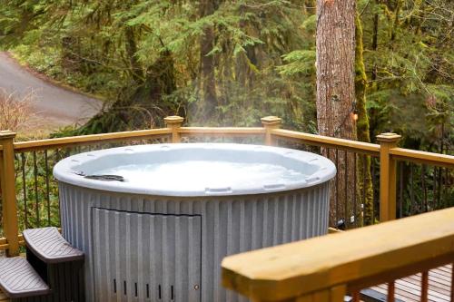 a hot tub on a deck with a wooden fence at Sweet Seclusion in Glacier