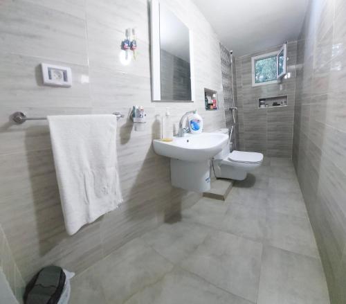 a white bathroom with a sink and a toilet at Hammamet sunrise in Hammamet