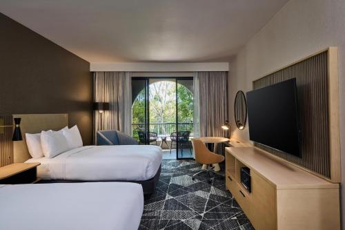 a hotel room with two beds and a flat screen tv at DoubleTree by Hilton Newark-Fremont in Newark