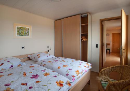 ein Schlafzimmer mit einem Bett mit geblümter Bettdecke in der Unterkunft Erlebnishof Katthusen in Otterndorf