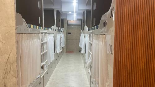 a large bathroom with white towels on the racks at Trio Rooms & dormitory in Trivandrum