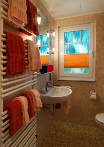 a bathroom with a sink and a window and towels at Erlebnishof Katthusen in Otterndorf