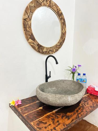 a bathroom with a stone sink and a mirror at TottyHouse Gili Trawangan in Gili Trawangan