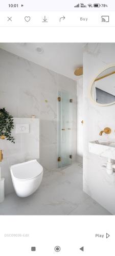 a white bathroom with a sink and a toilet at City tower 16 floor in Jerusalem