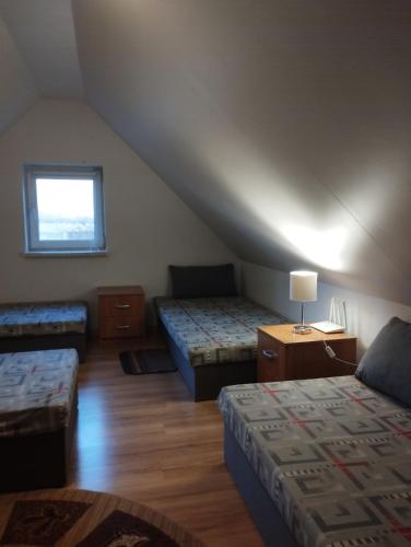 a room with three beds and a window at Domki pod brzózkami in Bodzentyn