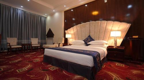a bedroom with a large bed with a large headboard at Kabul Star Hotel & Restaurant in Shīrpūr