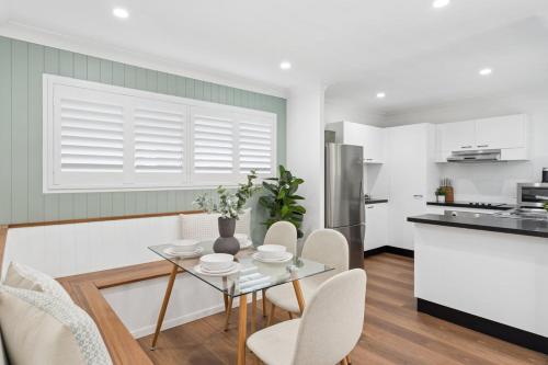 a kitchen with a table and chairs in a room at Unit 6 Nirvana in Yaroomba
