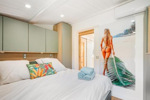 a room with two beds and a painting of a woman at Villa 52 Naturiste in Cap d'Agde