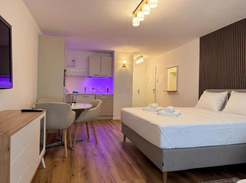 a bedroom with a bed and a kitchen with purple lights at Lorez 5A by Arosa Holiday in Arosa