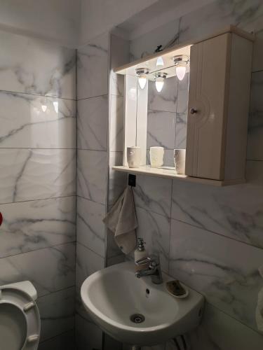 a white bathroom with a sink and a mirror at Billias House in Vourvourou
