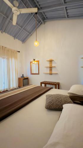 a bedroom with two beds and a ceiling fan at Richards Cabanas in Tissamaharama