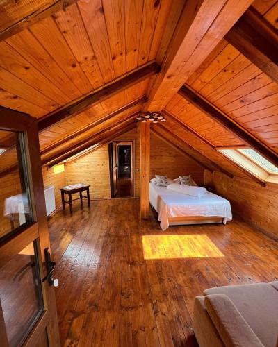 a large room with a bed in a wooden ceiling at Pensiunea Cambiano in Beliş