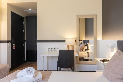 a bedroom with a bed and a desk with a chair at May Ramblas Hotel in Barcelona