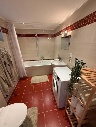 a bathroom with a tub and a toilet and a sink at Haus Haslauer in Strobl