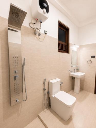a bathroom with a toilet and a shower and a sink at Prabha Garden Boutique Villa in Anuradhapura