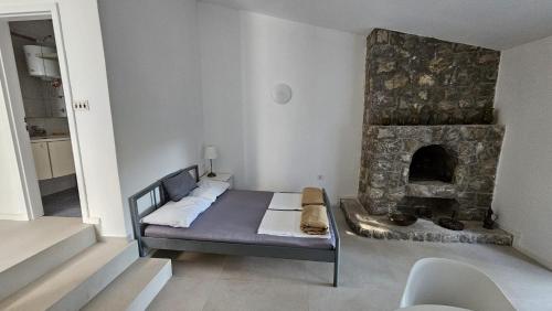 a bedroom with a bed and a stone fireplace at Apartments Peace&Love in Baška