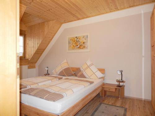 a bed in a room with a wooden ceiling at Ferienwohnungen Stark in Kelheim