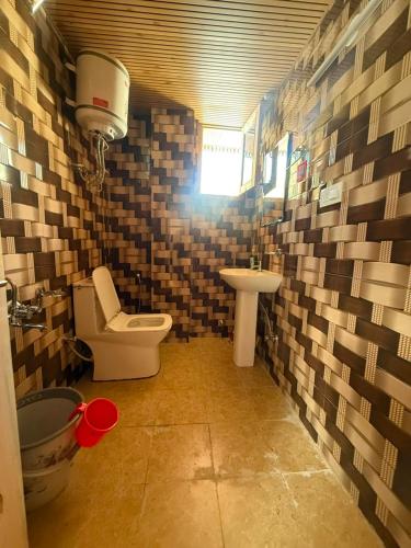 a small bathroom with a toilet and a sink at Himalyan Kitchen & Stay in Matiāna