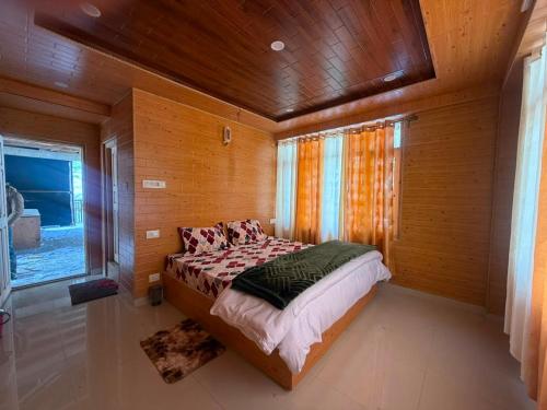 a bedroom with a bed in a room with wooden walls at Himalyan Kitchen & Stay in Matiāna