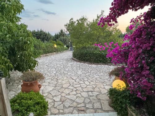 a stone walkway with purple flowers and plants at White House R&B in Campobello di Licata