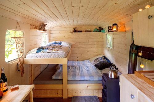 a bedroom in a tiny house with a bunk bed at Maringotka Vojenského Stylu na Šumavě in Bošice