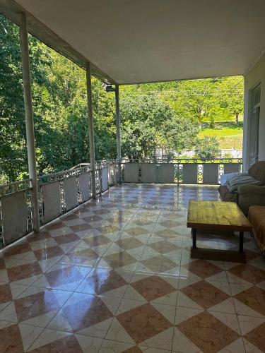 a screened in porch with a couch and a table at Guest hous Tamuna in Martvili