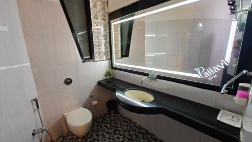 a bathroom with a sink and a toilet and a mirror at Pallavi West in Panchkula