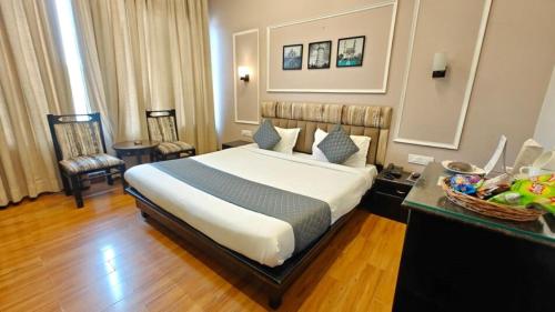 a hotel room with a bed and a table at Pallavi West in Panchkula