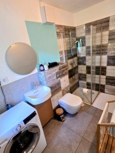 a bathroom with a sink and a washing machine at Tiny Apartments 07 - nahe am Viehofner See in Sankt Pölten