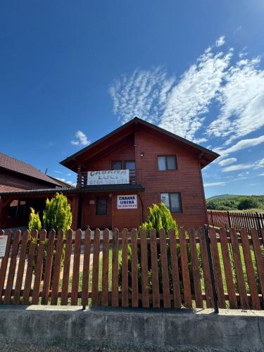 a wooden fence in front of a house at Cabana LUCI - FIGA in Beclean