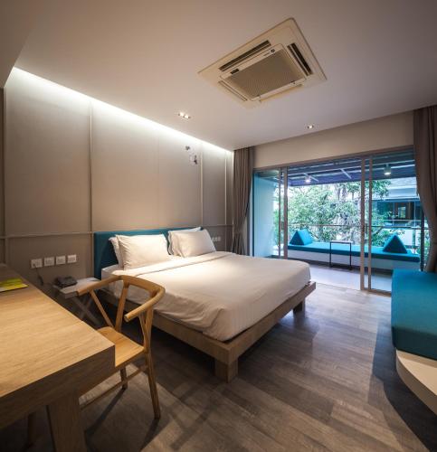 a bedroom with a bed and a large window at Bann Pantai Resort in Cha Am