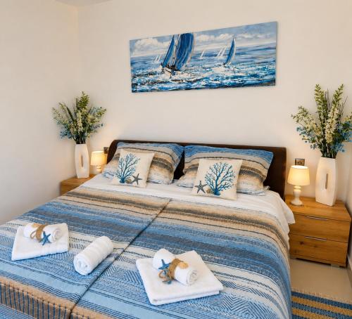 a bedroom with a bed with towels on it at Romantic Apartment Sonja, Beachfront in Cesarica