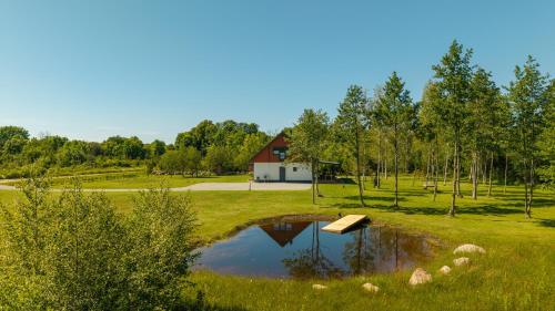 a pond in the middle of a field with a house at Ninase Villa in Ninaze