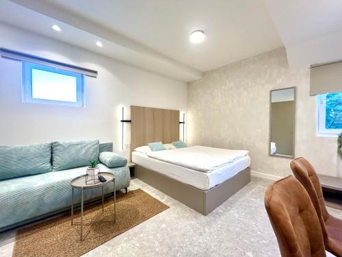 a bedroom with a bed and a couch at Deluxe Villa No.10 - Rooms & Apartments in Mandre