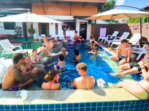 a group of people sitting in a swimming pool at K-Bunk Hostel Pai Walking Street in Pai