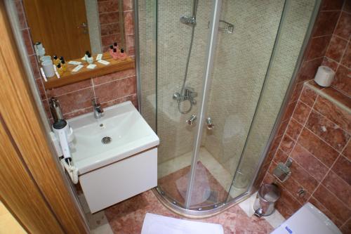 un baño con ducha y lavabo en Cunda Kivrak Hotel, en Ayvalık