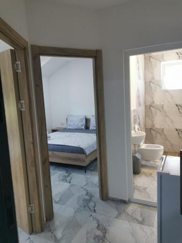 a bedroom with a bed and a bathroom with a mirror at Villa SeFa in Struga