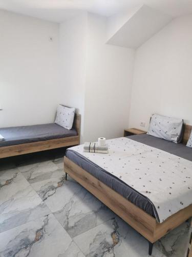 a bedroom with two beds and a tile floor at Villa SeFa in Struga