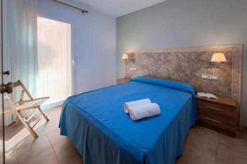 a bedroom with a blue bed with a towel on it at Euromar I - TEPINSA Alquiler de Apartamentos in Torreblanca