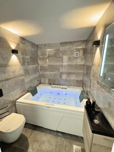 a bathroom with a large tub and a toilet at Sunrise Villa Lopar in Lopar